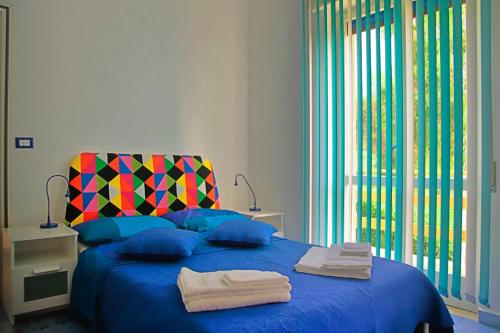 a bedroom with a blue bed with towels on it at Villa Doris in Fontane Bianche