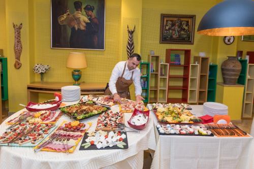 a man standing at a table with food on it at Hotel Lirak in Tetovo