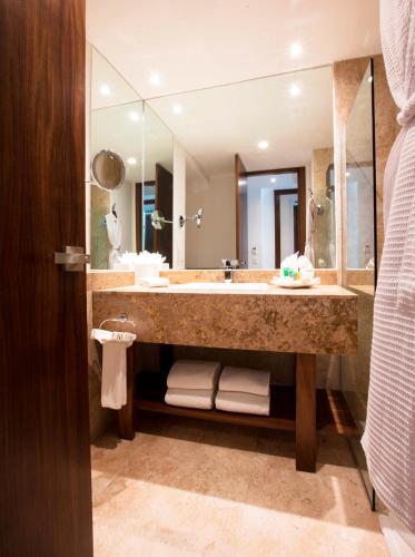 a bathroom with a large sink and a large mirror at Krystal Grand Nuevo Vallarta in Nuevo Vallarta 