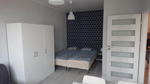 グディニャにあるMorska 74の小さなベッドルーム(ベッド1台、白いキャビネット付)