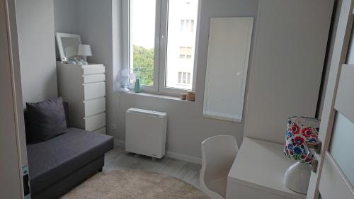 グディニャにあるMorska 74の小さな白い部屋で、椅子と窓が備わります。
