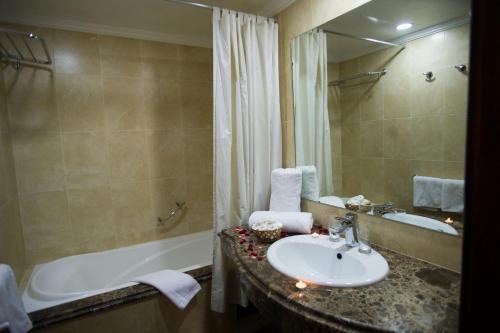 a bathroom with a sink and a bath tub at Hôtel Rif in Meknès