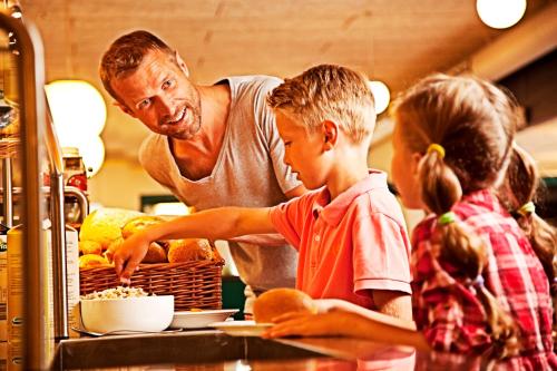 a man and a child preparing food in a kitchen at LEGOLAND Wilderness Barrels & Cabins in Billund