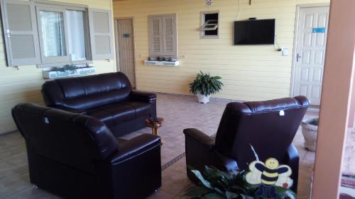 un soggiorno con 2 sedie e una TV di Pousada Campanário a Cambará