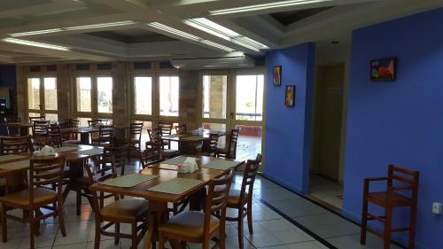a restaurant with wooden tables and chairs and blue walls at Rede Andrade Aracaju in Aracaju