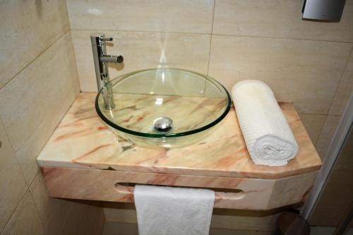 a glass sink on a wooden counter in a bathroom at Sol Hotel in Praia