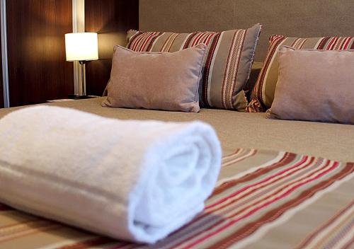 a bed with a white towel on it with pillows at Hotel UOM Buenos Aires in Buenos Aires