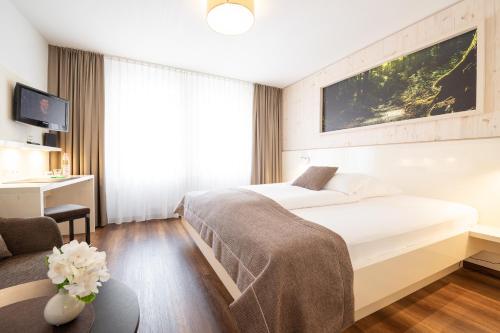 a hotel room with a bed and a couch at Weinstadt Hotel - das Original in Weinstadt