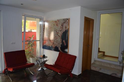 a living room with two red chairs and a window at Sol Hotel in Praia