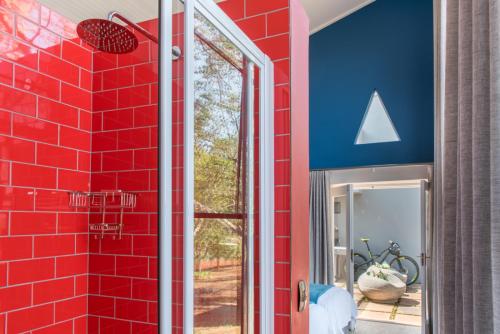 a red tile wall in a bathroom with a shower at Bluemere Living in White River