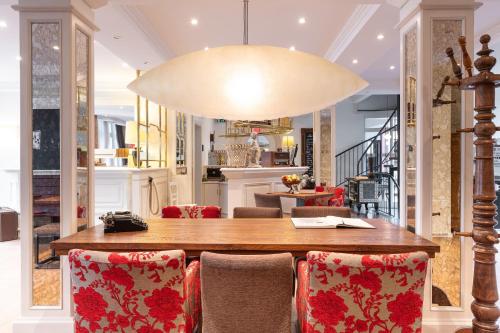 a dining room table with chairs and a large light fixture at Weinstadt Hotel - das Original in Weinstadt