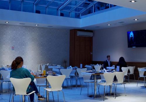 a group of people sitting at tables in a room at Hotel UOM Buenos Aires in Buenos Aires