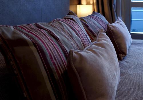 a pile of pillows sitting on top of a bed at Hotel UOM Buenos Aires in Buenos Aires