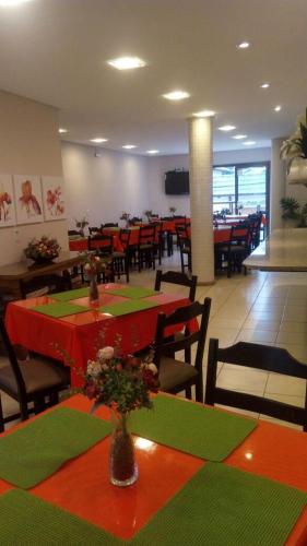 a restaurant with red and green tables and chairs at Vital Hotel in Marechal Floriano