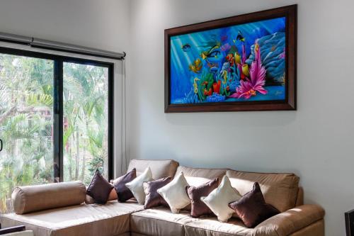 a living room with a couch with a painting on the wall at Hidden Palms in Nosara