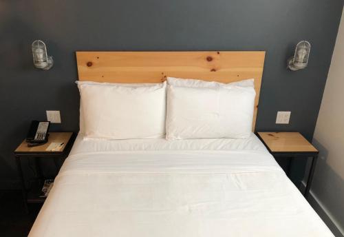 a bed with white sheets and pillows in a room at Bklyn House Hotel New York Brooklyn in Brooklyn