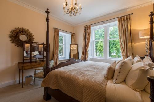a bedroom with a bed and a chandelier at Altskeith Country House in Aberfoyle