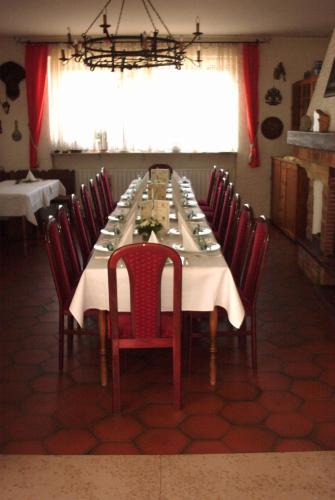 a dining room with a table with red chairs at Hotel Bürgerhof in Homburg