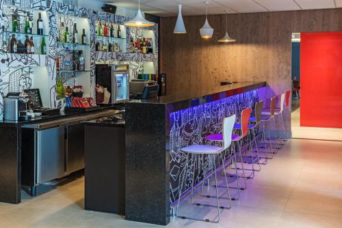 a bar with purple stools in a restaurant at ibis Santos Valongo in Santos