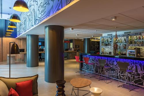 a bar in a restaurant with purple and red chairs at ibis Santos Valongo in Santos