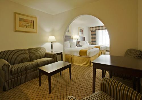 a hotel room with a bed and a couch and a room at Holiday Inn Express Childress, an IHG Hotel in Childress