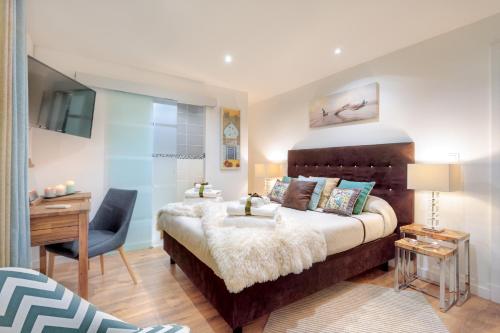 a bedroom with a bed and a desk and a chair at La Villa Des Sens in Lattes