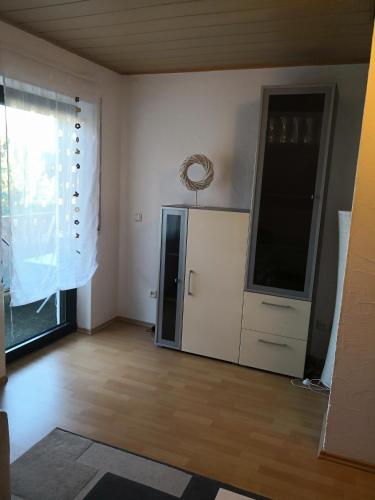 a living room with a refrigerator and a window at Ferienwohnung Schmeisser in Kirchenpingarten