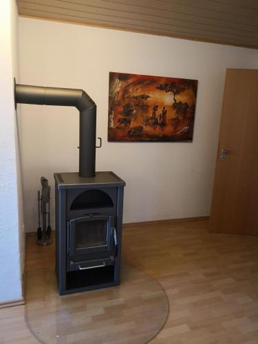 a stove in a room with a painting on the wall at Ferienwohnung Schmeisser in Kirchenpingarten