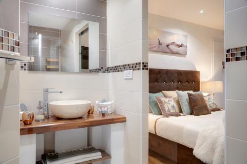 a bathroom with a sink and a bed at La Villa Des Sens in Lattes