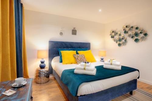 a bedroom with a bed with blue and yellow pillows at La Villa Des Sens in Lattes