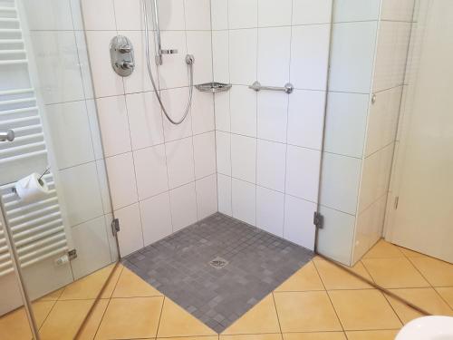 a bathroom with a shower with a tile floor at HR Townhouse Honigbach in Coesfeld