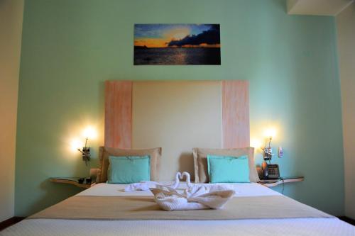 a bedroom with a bed with towels on it at Sol Hotel in Praia