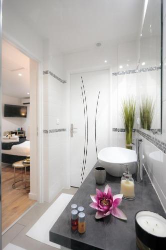 a bathroom with a white tub and a sink and a bath room at La Villa Des Sens in Lattes