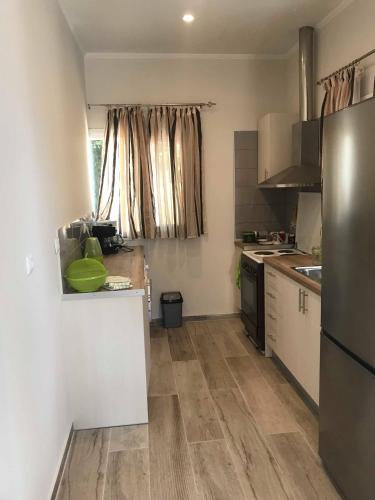 a small kitchen with white cabinets and a refrigerator at Stami's Seaside Apartment in Pyrgi