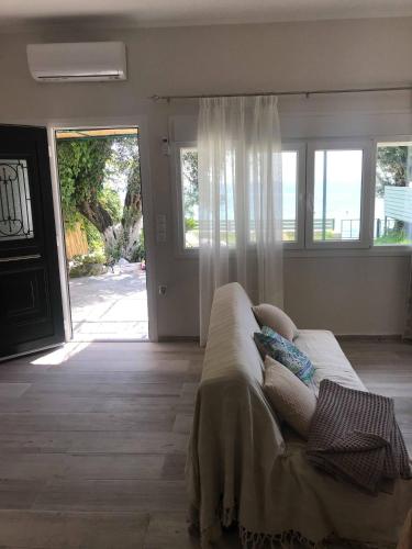 a living room with a couch in front of a door at Stami's Seaside Apartment in Pyrgi