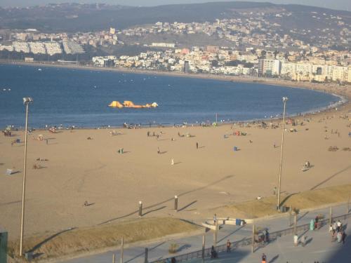 a group of people on a beach near the water at Hotel Miramar in Tangier