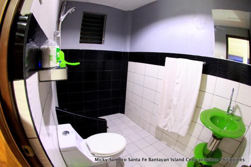 a bathroom with a toilet and a green sink at Micky Santoro Hotel & Restaurant in Bantayan Island