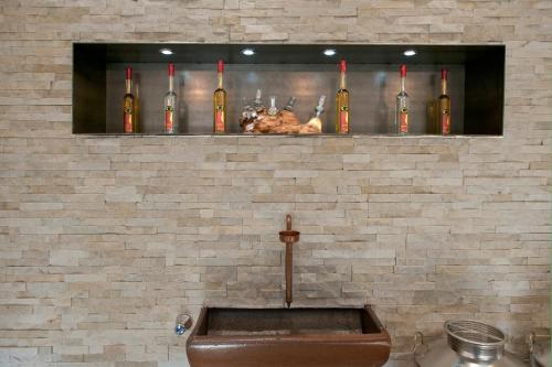 a wall with a shelf with bottles of wine at Hotel Thaler in Rietz