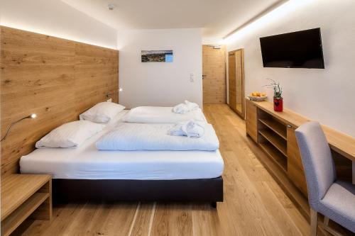 a hotel room with a bed and a television at Wellness Aparthotel Panorama Alpin - Ferienwohnungen Jerzens im Pitztal in Jerzens