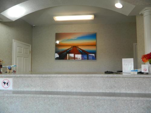 a lobby with a picture of a bridge on the wall at Village Inn & Suites - Smithville in Smithville