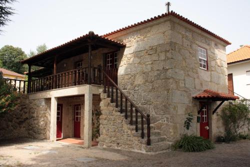 an old stone house with a staircase in front of it at Casa do Notário in Amares
