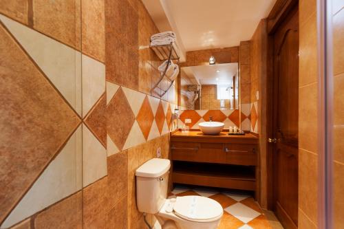 a bathroom with a toilet and a sink at Inti Punku Machupicchu Hotel & Suites in Machu Picchu