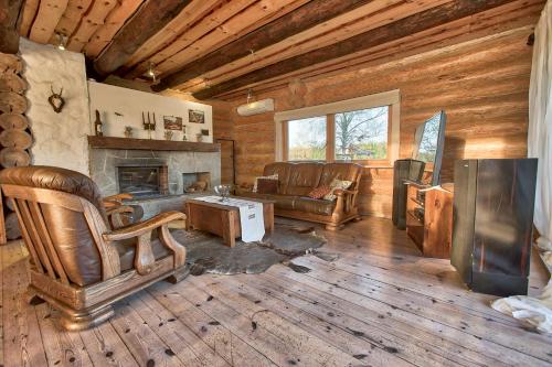 a living room with a couch and a fireplace at Saarelux Riverise Villa in Mõraste