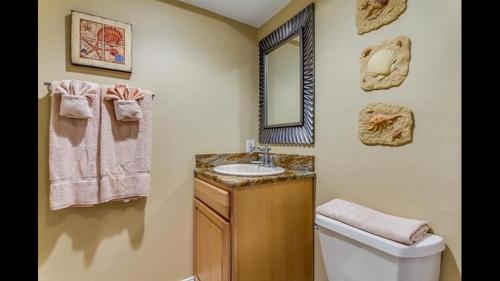 ein Badezimmer mit einem Waschbecken, einem WC und einem Spiegel in der Unterkunft Holiday Villas III #311 in Clearwater Beach