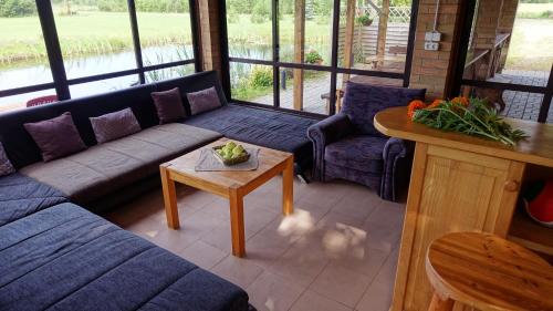 a living room with a blue couch and a table at Raudonkalnis in Mankiškiai