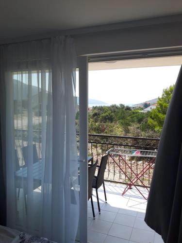 a room with a balcony with a table and chairs at Apartmani Dalmacjia in Grebaštica