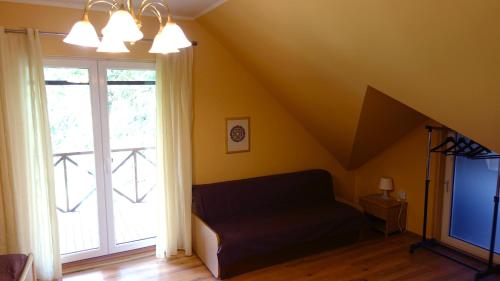 a attic room with a couch and a window at Raudonkalnis in Mankiškiai