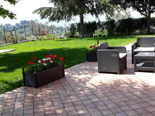 a patio with two chairs and flowers in a park at La Quiete in Anagni