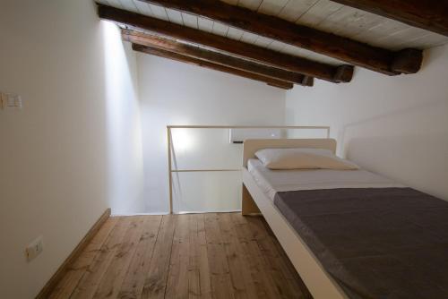 a small bedroom with a bed and a wooden floor at Ficodì apartments in Alcamo