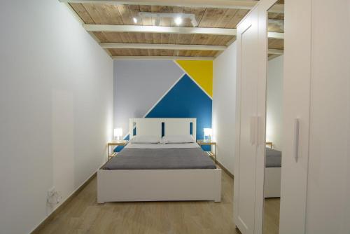 a bedroom with a bed and a colorful wall at Ficodì apartments in Alcamo